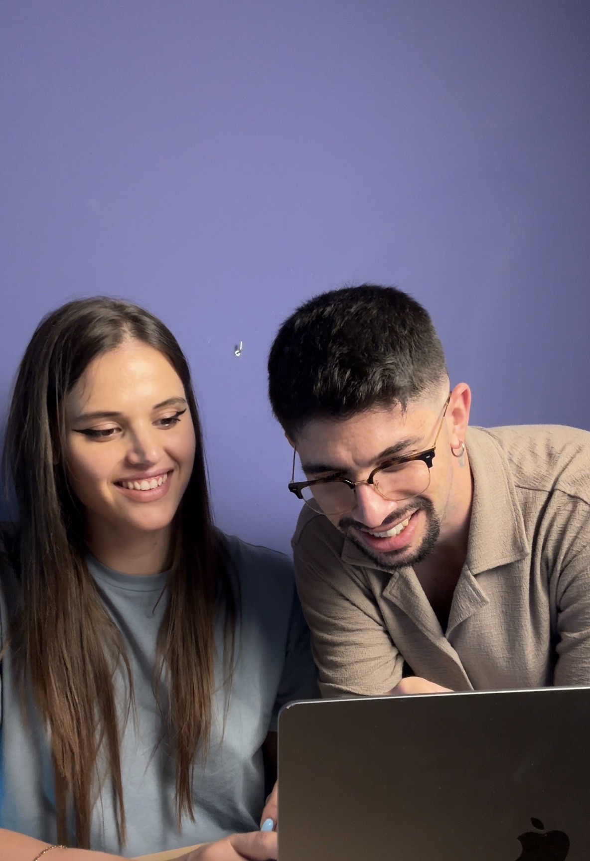 Fabio e Martina, fondatori di Crimini di Comunicazione, al lavoro su un laptop